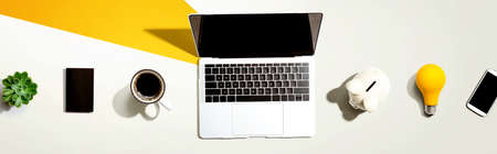 Laptop computer with a piggy bank and office objectsの写真素材