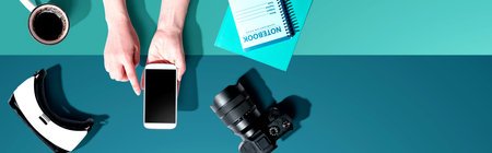 Person using a smartphone with a VR and a SLR camera