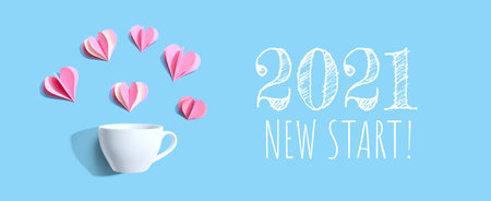 2021 New Start message with a coffee cup and paper hearts - flat lay