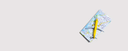 Travel theme with a miniature airplane and a map - flat lay