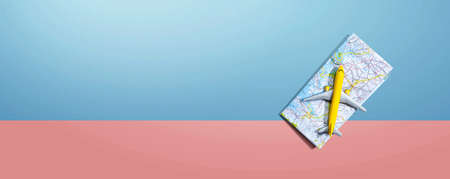 Travel theme with a miniature airplane and a map - flat lay