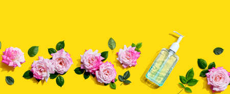 Sanitizer bottle with pink roses overhead view - flat lay