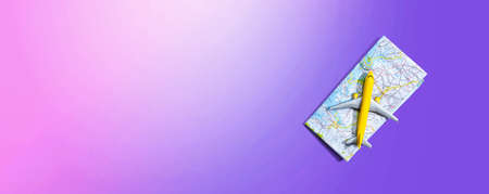 Travel theme with a miniature airplane and a map - flat lay
