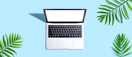 Laptop computer with tropical leavesの写真素材