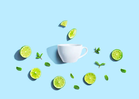 Fresh limes with tea cup overhead viewの写真素材