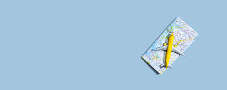 Travel theme with a miniature airplane and a map - flat lay