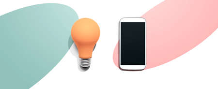 Smartphone with a yellow light bulbの写真素材
