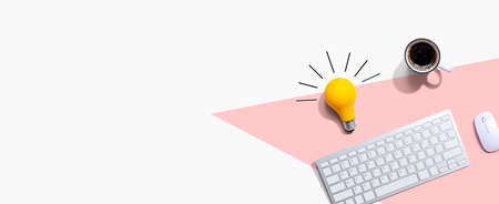 Computer keyboard with a yellow light bulbの写真素材