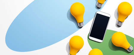 Smartphone with yellow light bulbsの写真素材