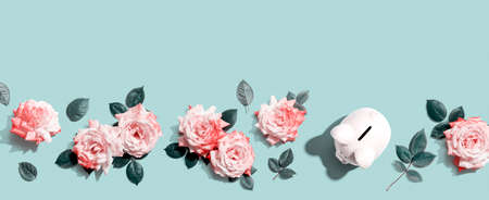 Piggy bank with pink roses overhead viewの写真素材