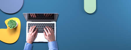 Person using a laptop computer with geometric shaped objects
