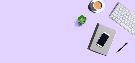 Desk items - keyboard, smart phone, coffee and a pen