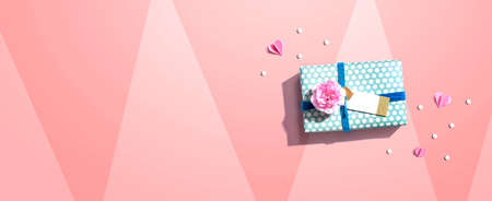 Gift box with a pink carnation flowerの写真素材