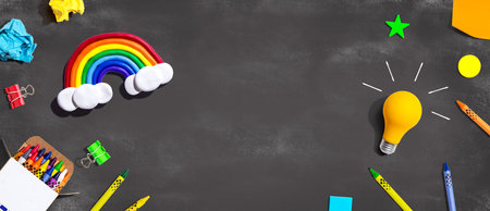 Idea light bulb with a rainbow and school supplies - flat lay
