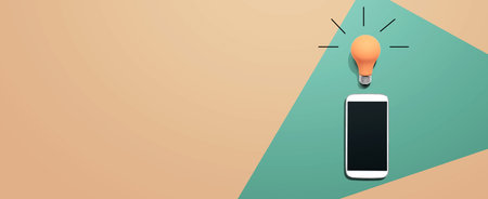 Smartphone with a yellow light bulbの写真素材