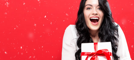 Happy young woman holding a Christmas gift box