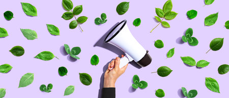 Person holding a megaphone with green leavesの写真素材