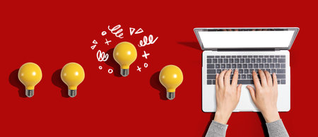 Idea light bulbs with person using a laptop computer