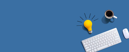Computer keyboard with a yellow light bulbの写真素材