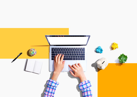 Laptop computer with a piggy bank and office objectsの写真素材