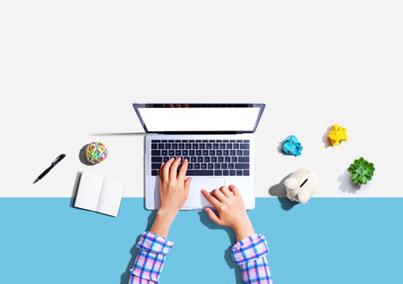 Laptop computer with a piggy bank and office objectsの写真素材