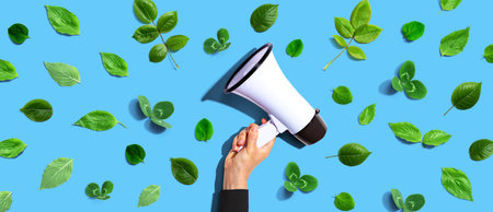 Person holding a megaphone with green leavesの写真素材
