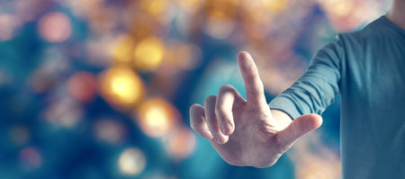 Young man pointing on blurred city light backgroundの写真素材