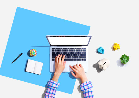 Laptop computer with a piggy bank and office objectsの写真素材