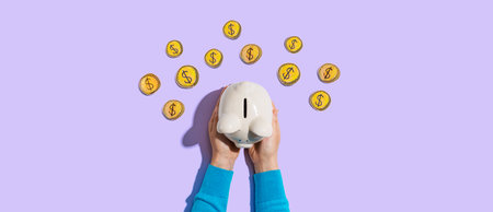 Person holding piggy bank with hand drawn coinsの写真素材