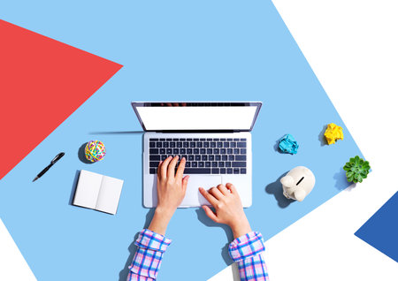 Laptop computer with a piggy bank and office objectsの写真素材