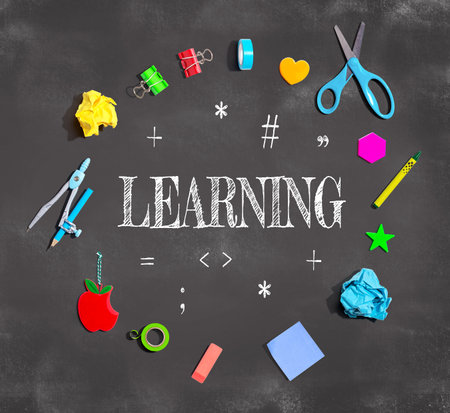 Learning concept with school supplies on a chalkboardの写真素材