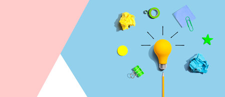 Brainstorming concept with a light bulb and school supplies - Flat layの写真素材