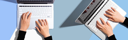 Two people working together with laptopの写真素材