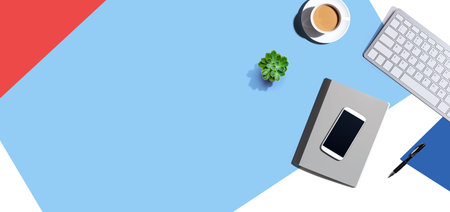 Desk items - keyboard, smart phone, coffee and a penの写真素材
