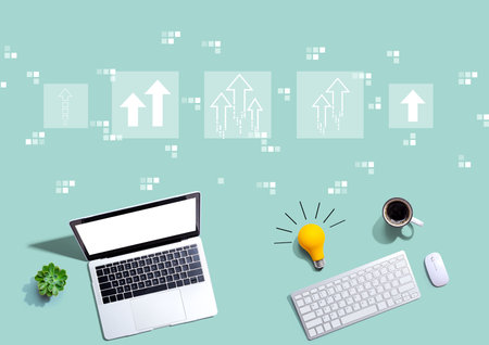 Rising arrow theme with computers with a light bulbの写真素材