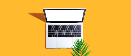 Laptop computer with tropical leafの写真素材