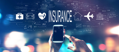 Insurance concept with a smartphone in city lights at nightの写真素材