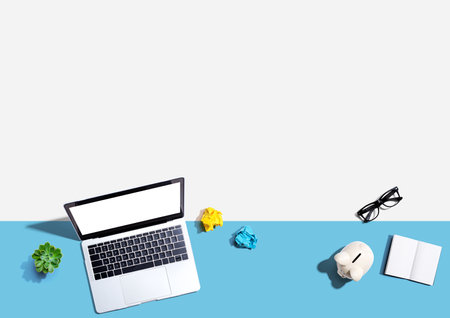 Laptop computer with a piggy bank and office objectsの写真素材