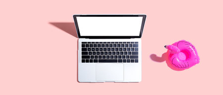 Laptop computer with a pink flamingoの写真素材