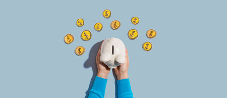 Person holding piggy bank with hand drawn coinsの写真素材
