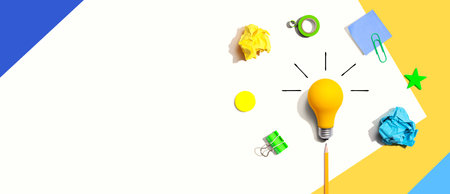 Brainstorming concept with a light bulb and school supplies - Flat layの写真素材