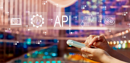 API - application programming interface concept with person using a smartphone in city at nightの写真素材