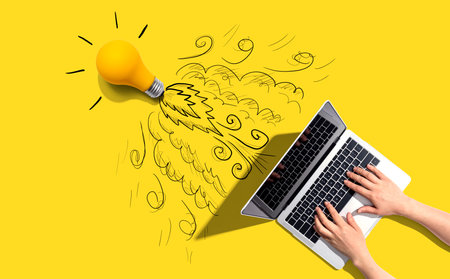 Idea light bulb flying to the sky like a rocket from a laptop computerの写真素材