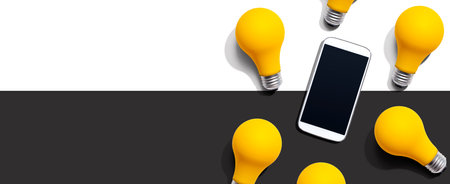 Smartphone with yellow light bulbsの写真素材