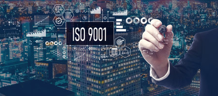 ISO 9001 theme with businessman in city at nightの写真素材