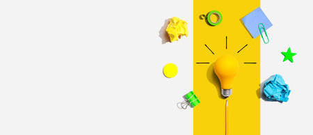 Brainstorming concept with a light bulb and school supplies - Flat lay