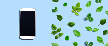White smartphone with green leavesの写真素材