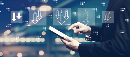 Descending arrows with businessman using a tabletの写真素材