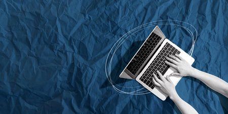 Person using a laptop computer with crumpled paper textureの写真素材