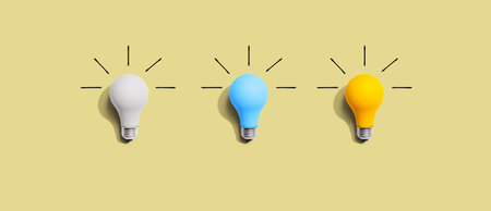 Idea and creativity concept with white, blue and yellow light bulbsの写真素材